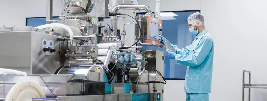Worker in clean facility touching a screen for food instrument.