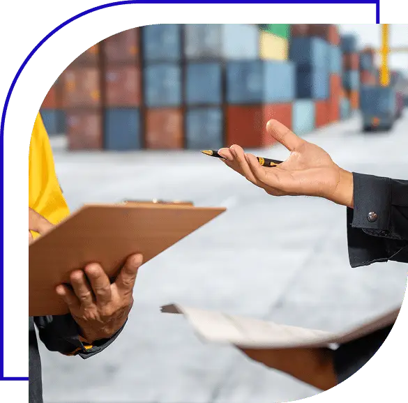 Two people discussing a shipment at a shipping container terminal.