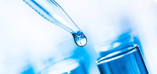Close up view of pipette with liquid drop on edge.