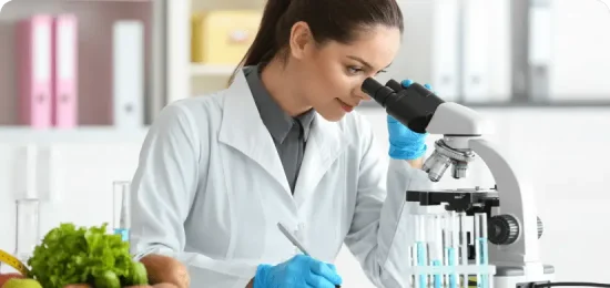 Young female nutritionist testing food samples in laboratory